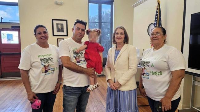 Carlos Yuniel Valle y su hija en brazos con la congresista Kathy Castor, los tres en el centro. 