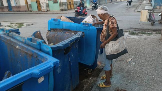 Una cubana busca en la basura.