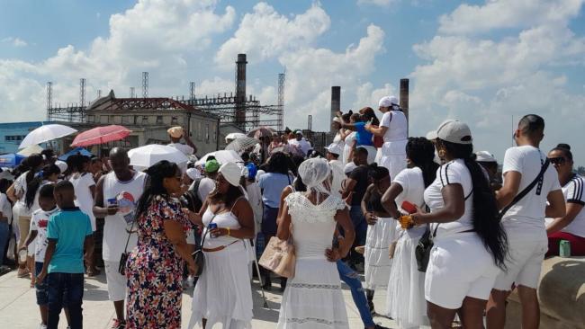 Mujeres, hombres y niños en una ceremonia religiosa.
