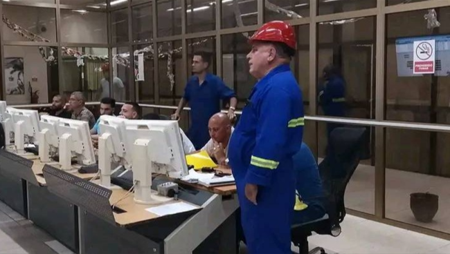 Operarios en un despacho de carga eléctrica.