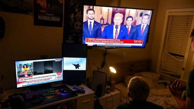 óvenes observan el discurso del presidente Donald Trump tras el ataque.