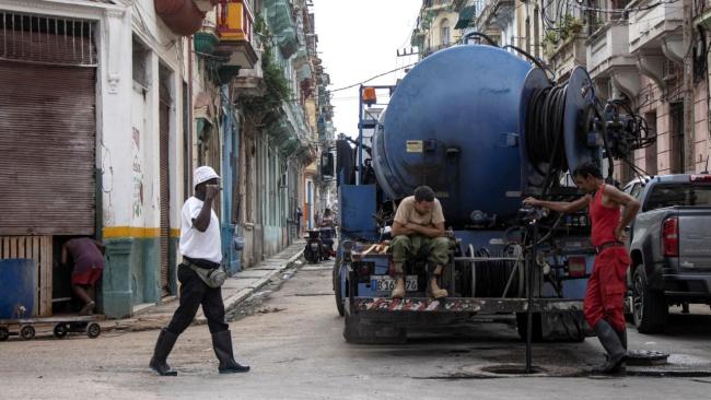 Trabajadores cubanos realizan labores en el alcantarillado en La Habana.