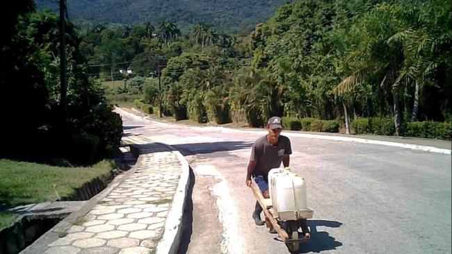 Un joven cubano carga agua en Buey Arriba.