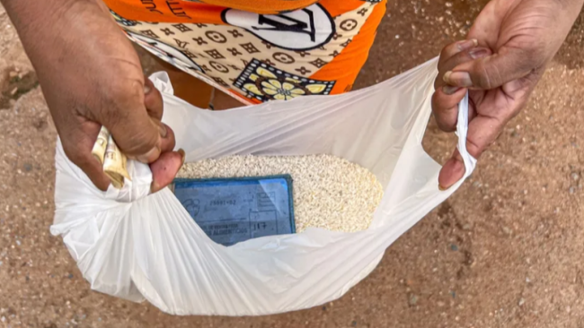 Una cubana exhibe el arroz que compró por la libreta de racionamiento.