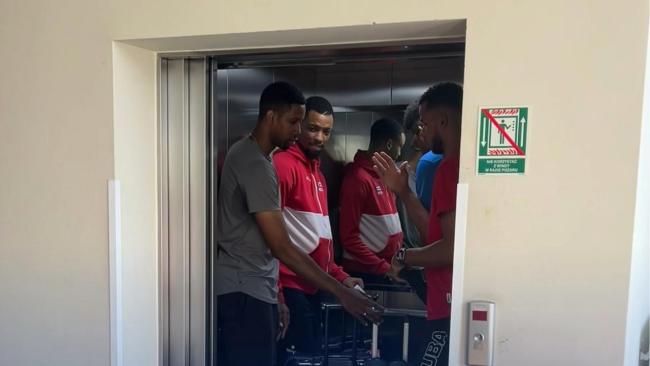Wilfredo León (pulóver gris) en un elevador junto al equipo cubano.