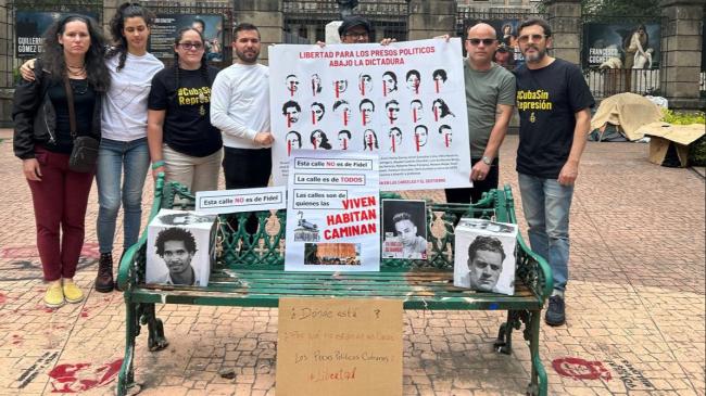 Exiliados cubanos en México portan imágenes de presos políticos.