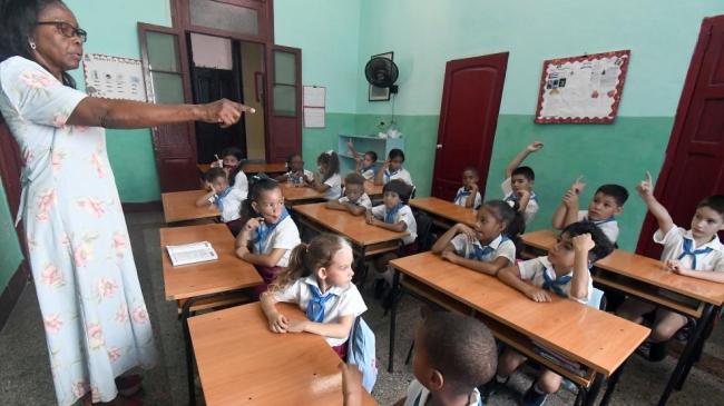 Una maestra ante un aula de enseñanza primaria en Cuba.