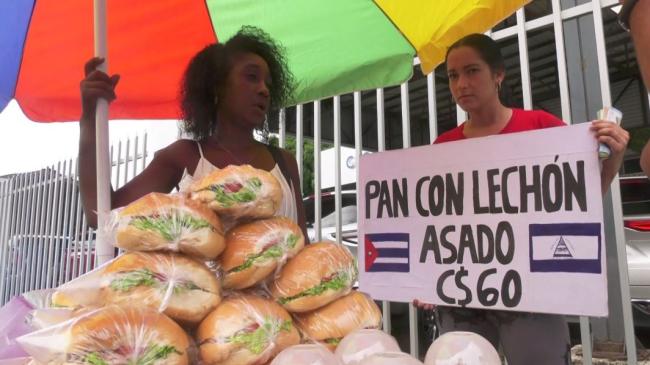 Cubanas con una venta de pan con lechón en Managua.