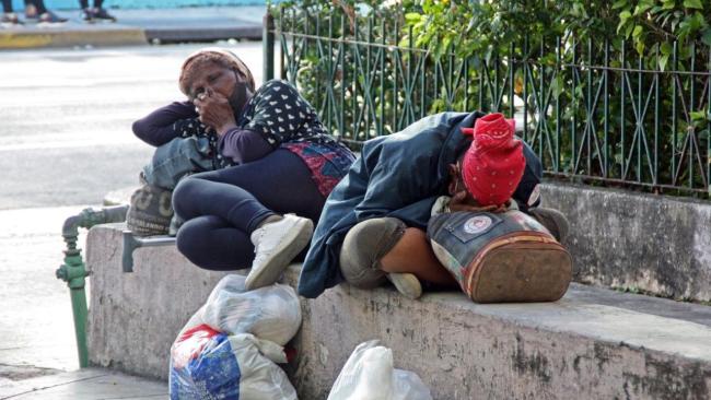 Dos mujeres duermes en un parque de La Habana.