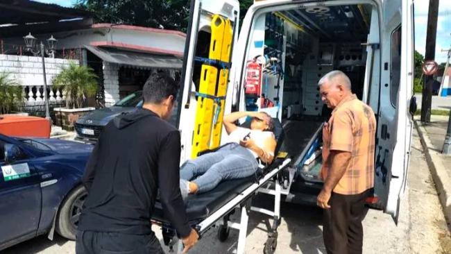 Una mujer afectada por el brote es trasladada en una ambulancia.