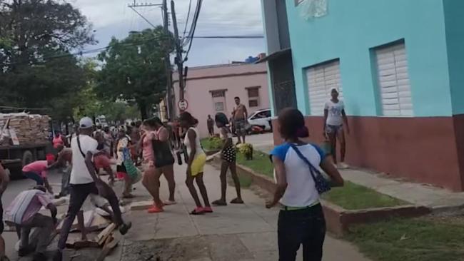 Santiagueros recogiendo las cajas de picadillo y pollo.