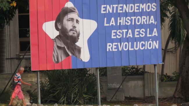 Un cubano ante una valla alegórica a Fidel Castro.