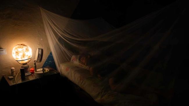 Un niño duerme bajo un mosquitero en una vivienda en Matanzas.