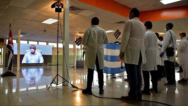 Médicos cubanos escuchan las instrucciones de Miguel Díaz-Canel.