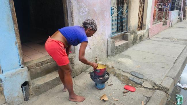 Una mujer en Santiago de Cuba cocina en la calle tras el paso de Melissa.