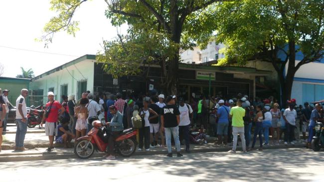 Aglomeración de cubanos frente a una sucursal bancaria.