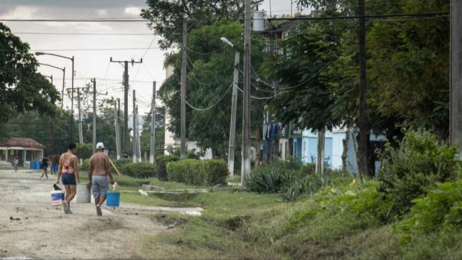 Cubanos cargando agua en Granma tras el paso del huracán Melissa.