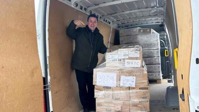 El padre Bladimir Navarro colocando paquetes destinados a Cuba en un camión.