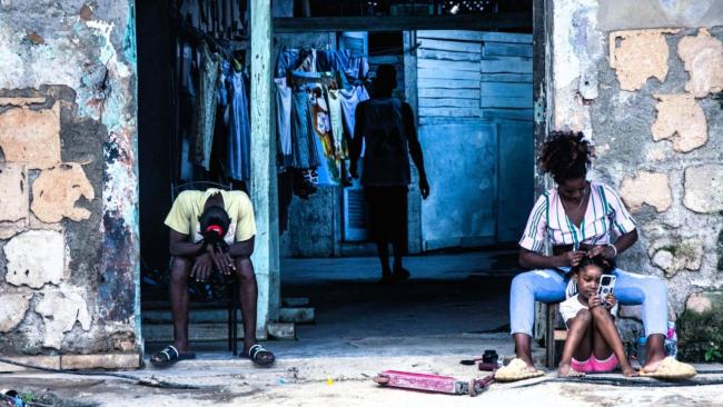 Cubanos en el exterior de viviendas en La Habana.