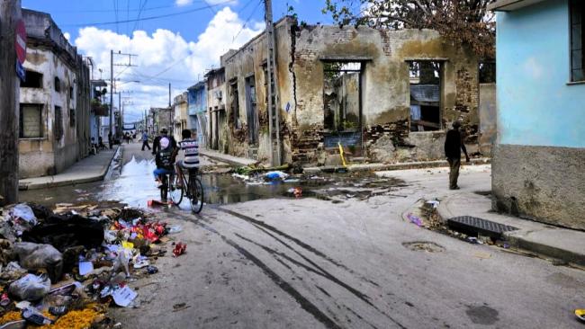Un salidero y mucha basura en una calle de Santiago de Cuba tras Melissa.