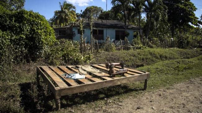 Bienes al sol frente a una vivienda dañada por Melissa en Granma.
