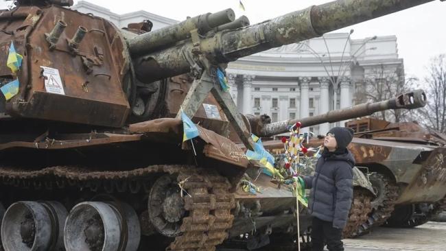 Un niño ucraniano ante unos tanques en Kiev. 