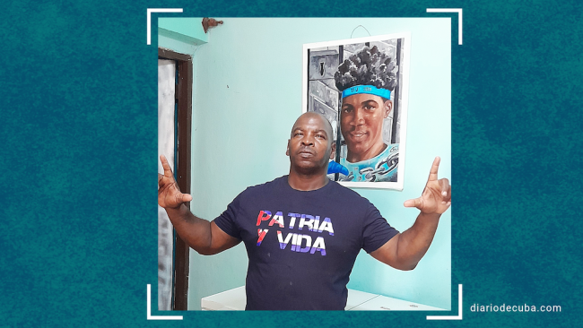 Wilber Aguilar Bravo ante una foto de su hijo Walnier, preso político del 11J con discapacidad intelectual.