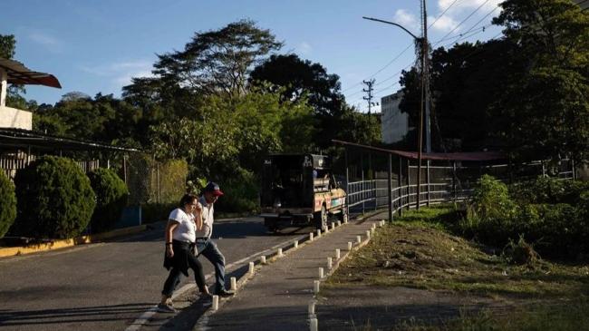 Dos personas caminan frente al centro penitenciario Rodeo en Zamora, Venezuela, el 13 de enero de 2026.  