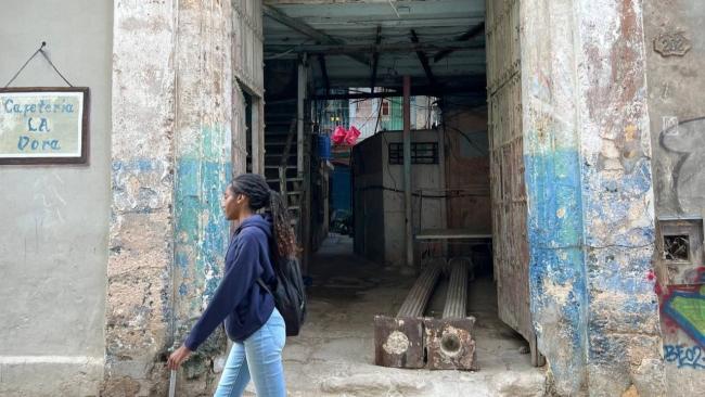 Una joven pasa por delante de un portal apuntalado en La Habana Vieja.