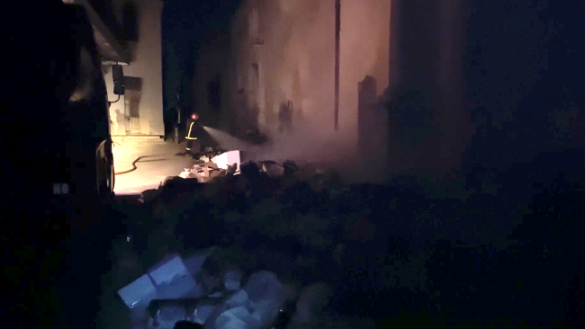Un bombero apaga basura incendiada en La Habana.