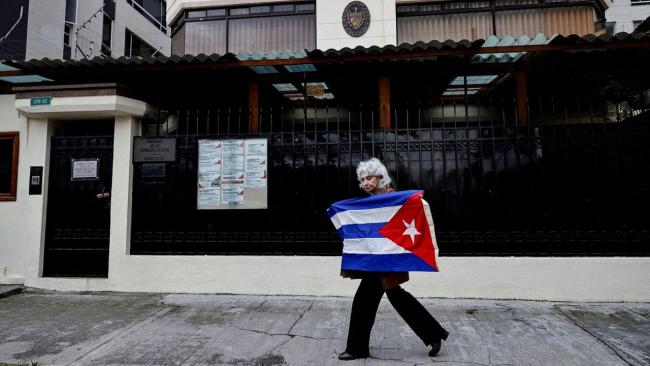 Una mujer frente a la Embajada del régimen de Cuba en Quito.