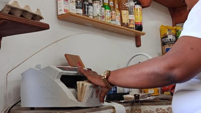 Una empleada cuenta billetes en una máquina.