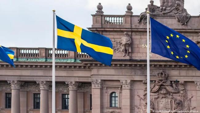 Las banderas de Suecia y la Unión Europea ondean frente al Parlamento sueco, el Riksdaghuset.