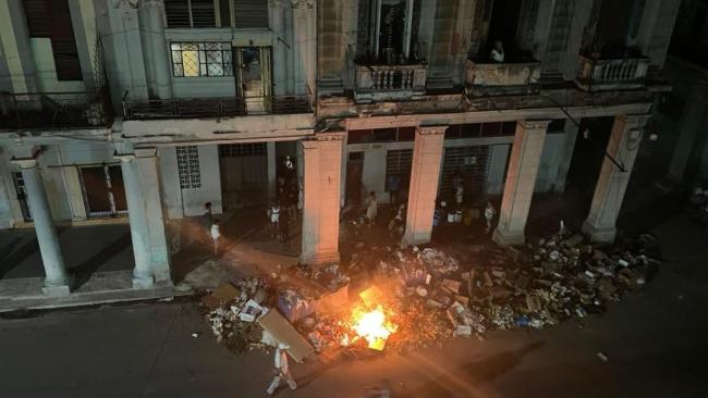 Vecinos con cubos a la espera de los bomberos.