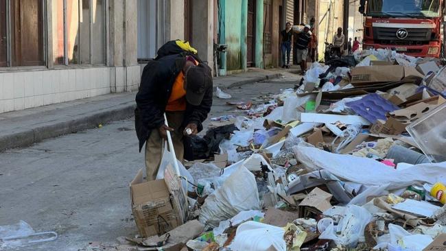 Un hombre busca en la basura en La Habana.