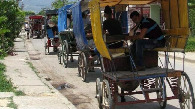 Coches de caballos en una calle en Cuba.