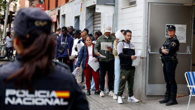 Cola de inmigrantes para realizar trámites en España.