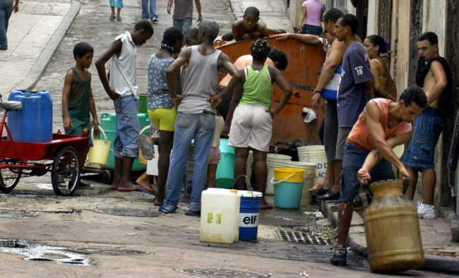 Cubanos abasteciéndose de agua con un camión cisterna.