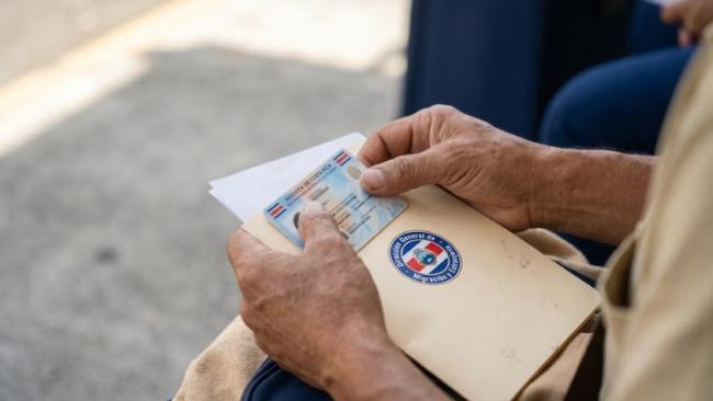 Un hombre sostiene documentos de Costa Rica.