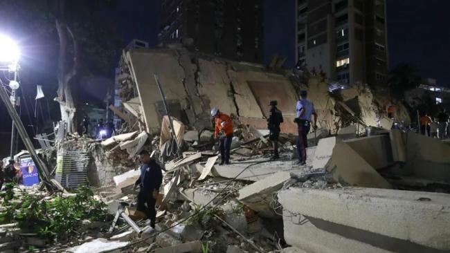 Rescatistas buscan víctimas este miércoles en una edificación colapsada en Caracas.