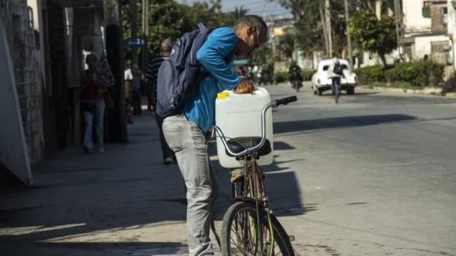 Un cubano cargando agua.