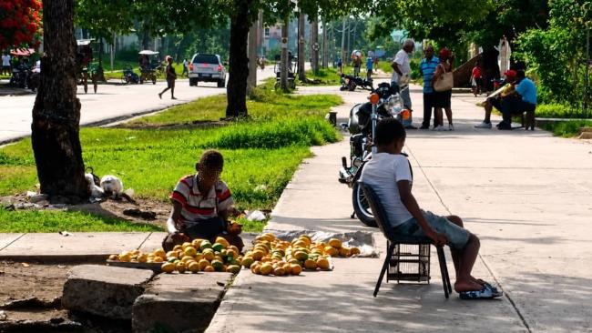Un niño vende mangos en Santiago de Cuba.