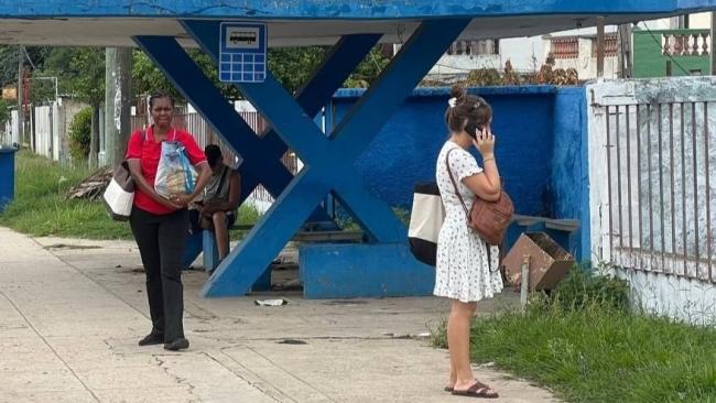 Dos mujeres cubanas en una parada en Boyeros, La Habana.