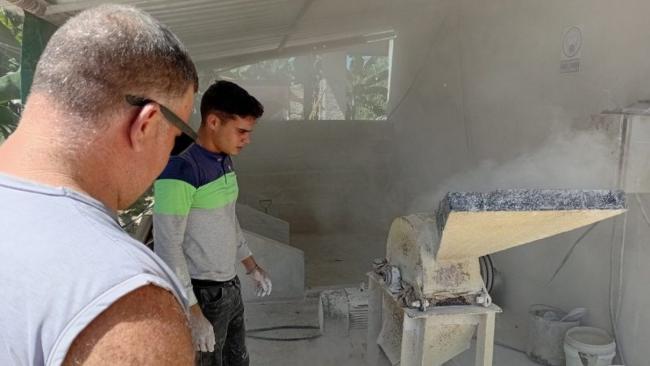 Trabajadores de CALYPM con su línea de producción de pinturas.