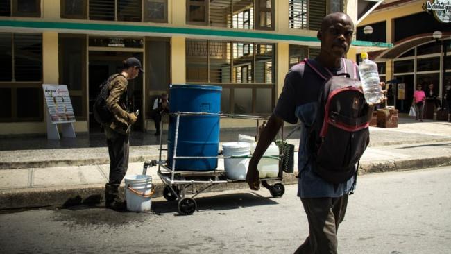 Cubanos cargando agua debido al desabastecimiento.