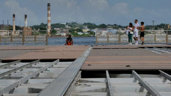 Personas al sol en el puente flotante de La Habana.