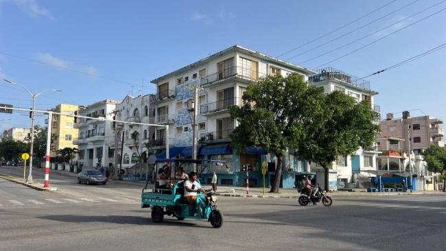Unos pocos vehículos circulan por la Calle 23 en La Habana.