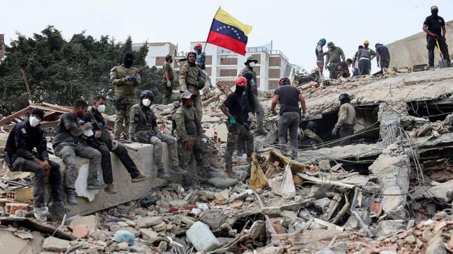 Rescatistas entre escombros de un edificio destruido por los terremotos en Venezuela.