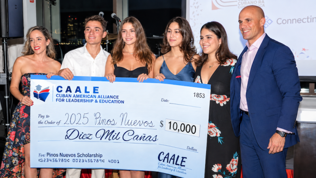 Adam San Miguel (d) entrega la beca Pinos Nuevos 2025 a estudiantes.