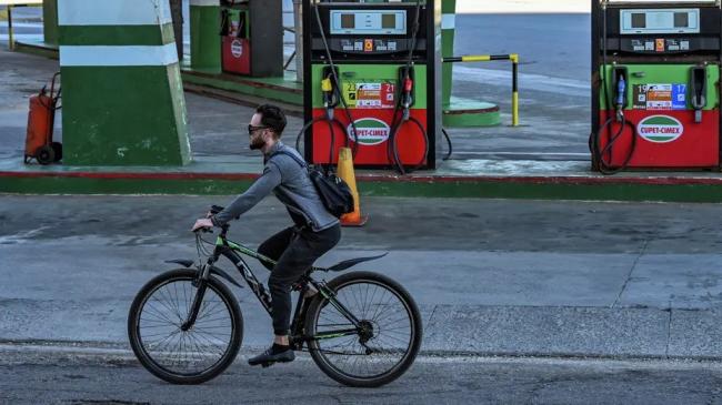 Un ciclista frente a una gasolinera en La Habana.